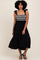 woman wearing a black tiered maxi dress with embroidered bodice and shoulder ties, standing against a neutral backdrop