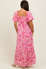 woman wearing a pink floral maternity maxi dress with puff sleeves and a smocked back detail