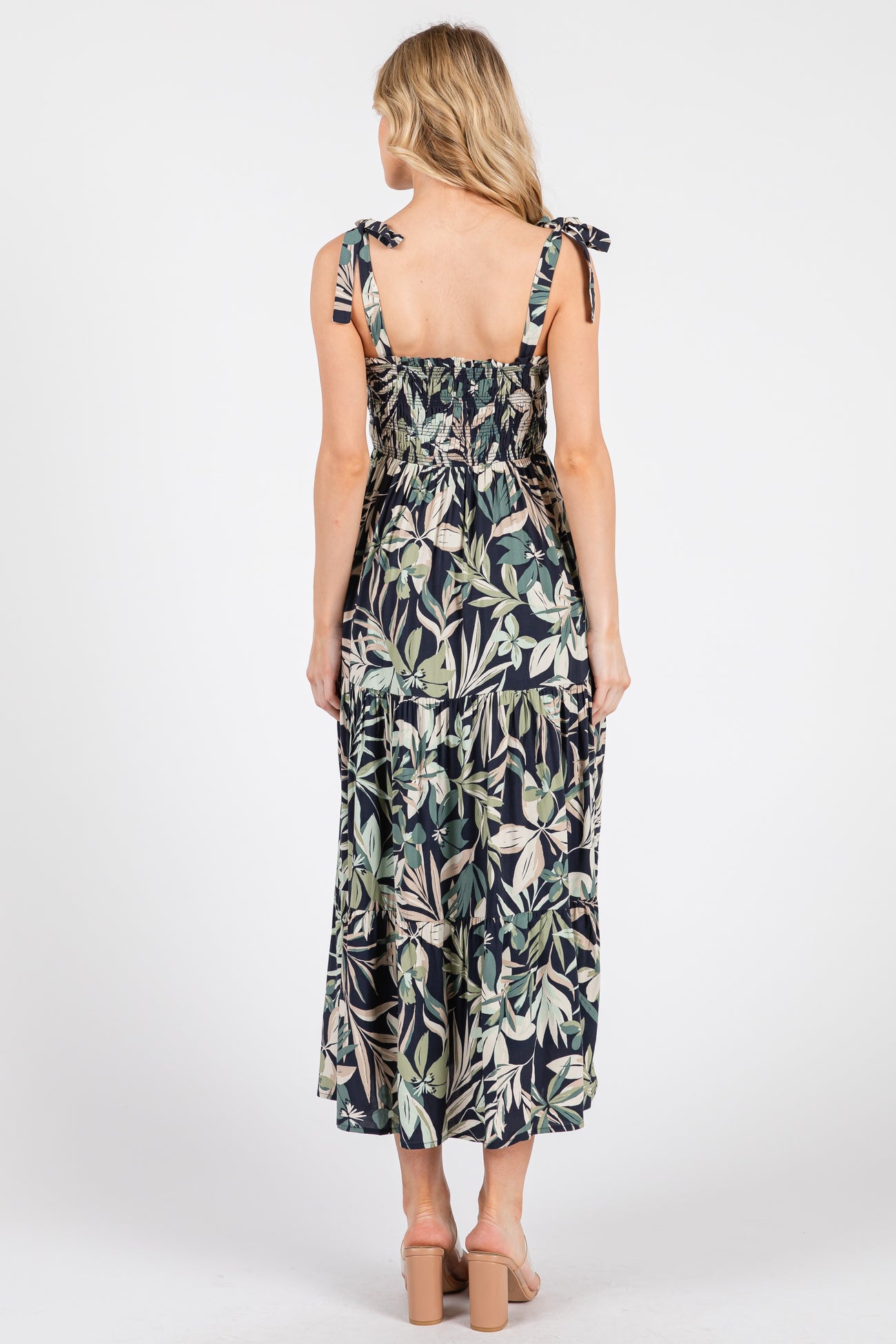 woman wearing a floral maxi dress with tie straps and a smocked bodice, shown from the back