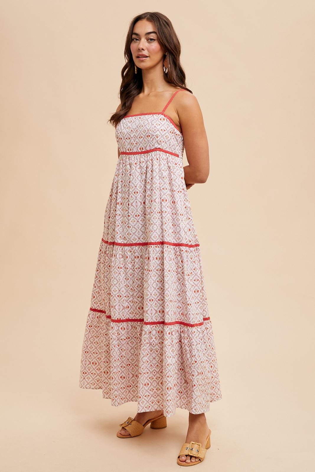 woman wearing a white maxi dress with red geometric patterns and adjustable straps