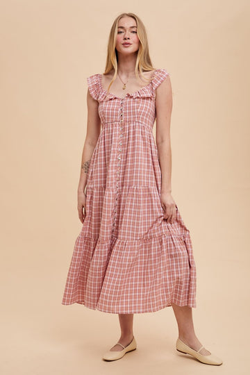 woman wearing a pink and white checked midi dress with ruffled straps and button details