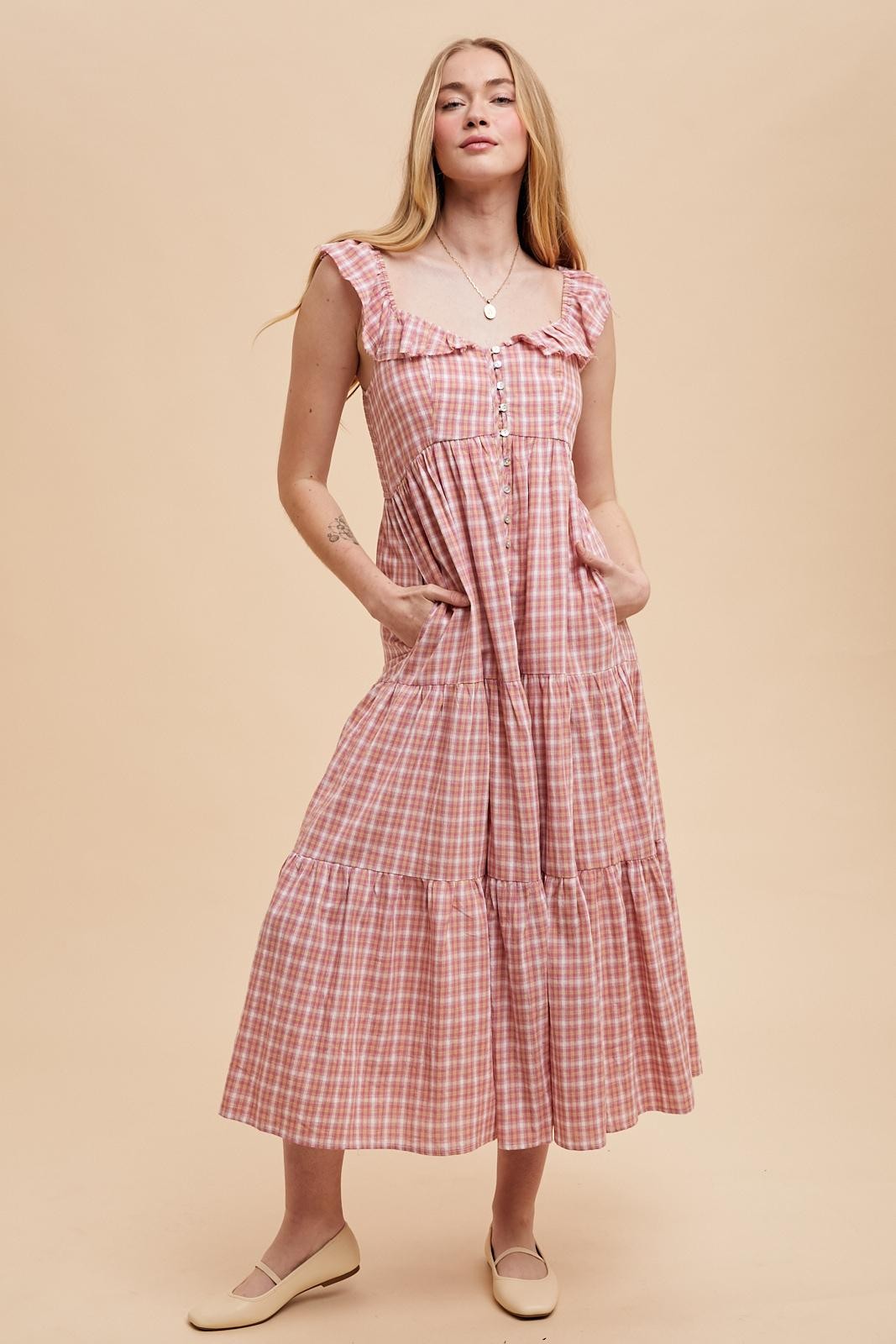 woman wearing a pink and white gingham maxi dress with ruffle straps and pockets