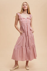 woman wearing a pink and white gingham maxi dress with ruffle straps and pockets