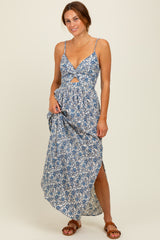 woman wearing a blue floral maxi dress with a twist front and side slit