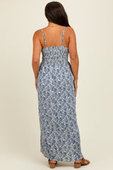 woman wearing a blue floral print maternity maxi dress with adjustable spaghetti straps and a smocked back