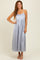 woman wearing a light blue satin maxi dress with a fitted bodice and flowing skirt, standing and smiling