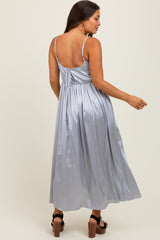 woman wearing a silver satin maternity maxi dress with adjustable straps and a gathered back design