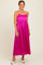 woman wearing a bright pink sleeveless maxi dress with a fitted bodice and flowing skirt