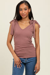 woman wearing a mauve ribbed tank top with tie shoulder details and a v-neck, paired with blue jeans