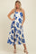 woman wearing a white maternity dress with blue floral print and a baby bump visibles