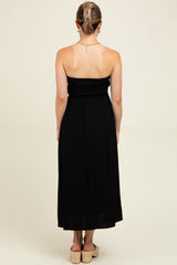 woman wearing a black maternity maxi dress with a smocked bodice, shown from the back