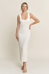 woman wearing a white ribbed knit sleeveless maxi dress with a scoop neckline and a fitted silhouette