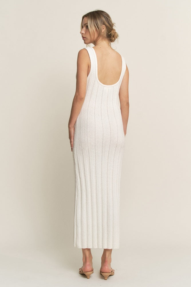 woman wearing a white ribbed knit sleeveless maxi dress with an open back, standing against a neutral background