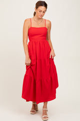 woman wearing a red tiered maxi dress with thin straps and a fitted bodice