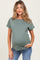 woman wearing an olive green ribbed maternity top and showing her baby bump while smiling