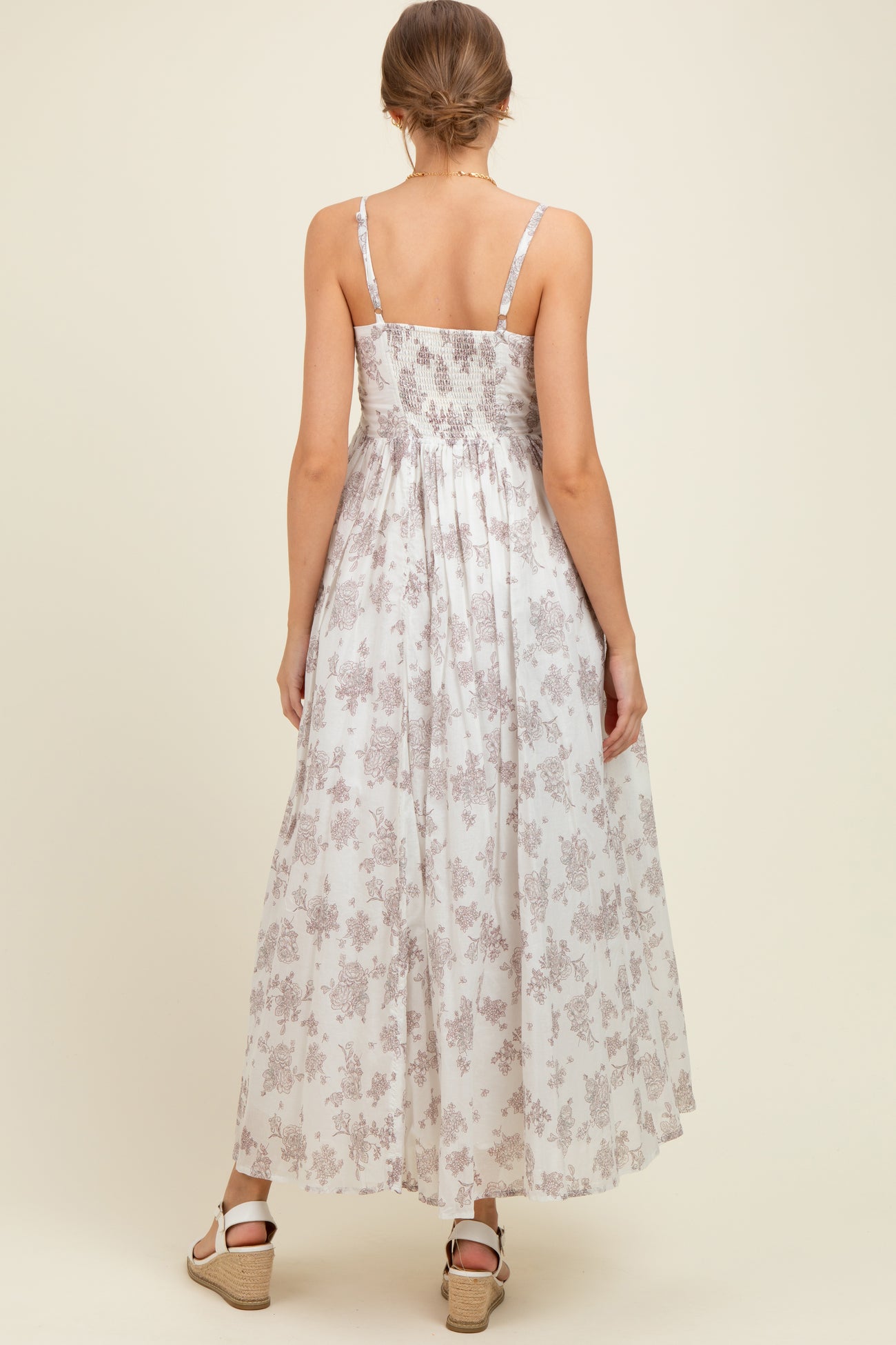 woman wearing a floral print maternity maxi dress with adjustable straps and a smocked back