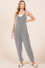 woman wearing a grey and white striped jumpsuit with adjustable straps and side pockets