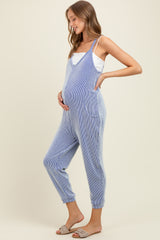 woman wearing a blue and white striped maternity jumpsuit, showing her baby bump, standing in a relaxed pose