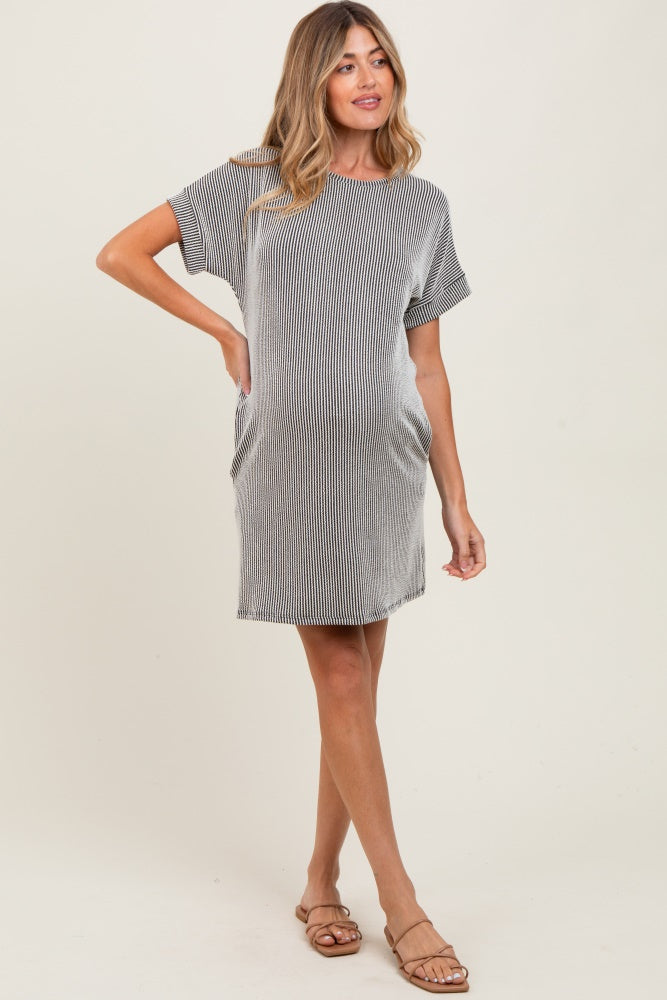 woman wearing a striped short sleeve maternity dress with side pockets and a visible baby bump