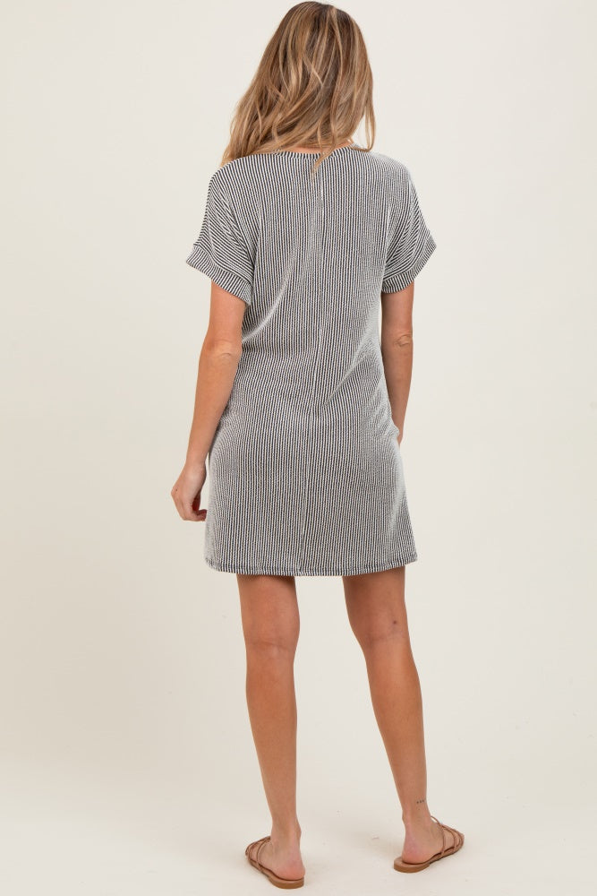 woman wearing a striped maternity t-shirt dress, seen from the back, with short sleeves and a relaxed fit