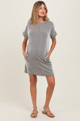 woman wearing a striped maternity dress with short sleeves and pockets, showcasing her baby bump