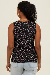 woman wearing a black sleeveless top with a floral print, viewed from the back, paired with light blue jeans