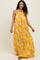 woman wearing a yellow halter neck maxi dress with white floral print and a flowing silhouette