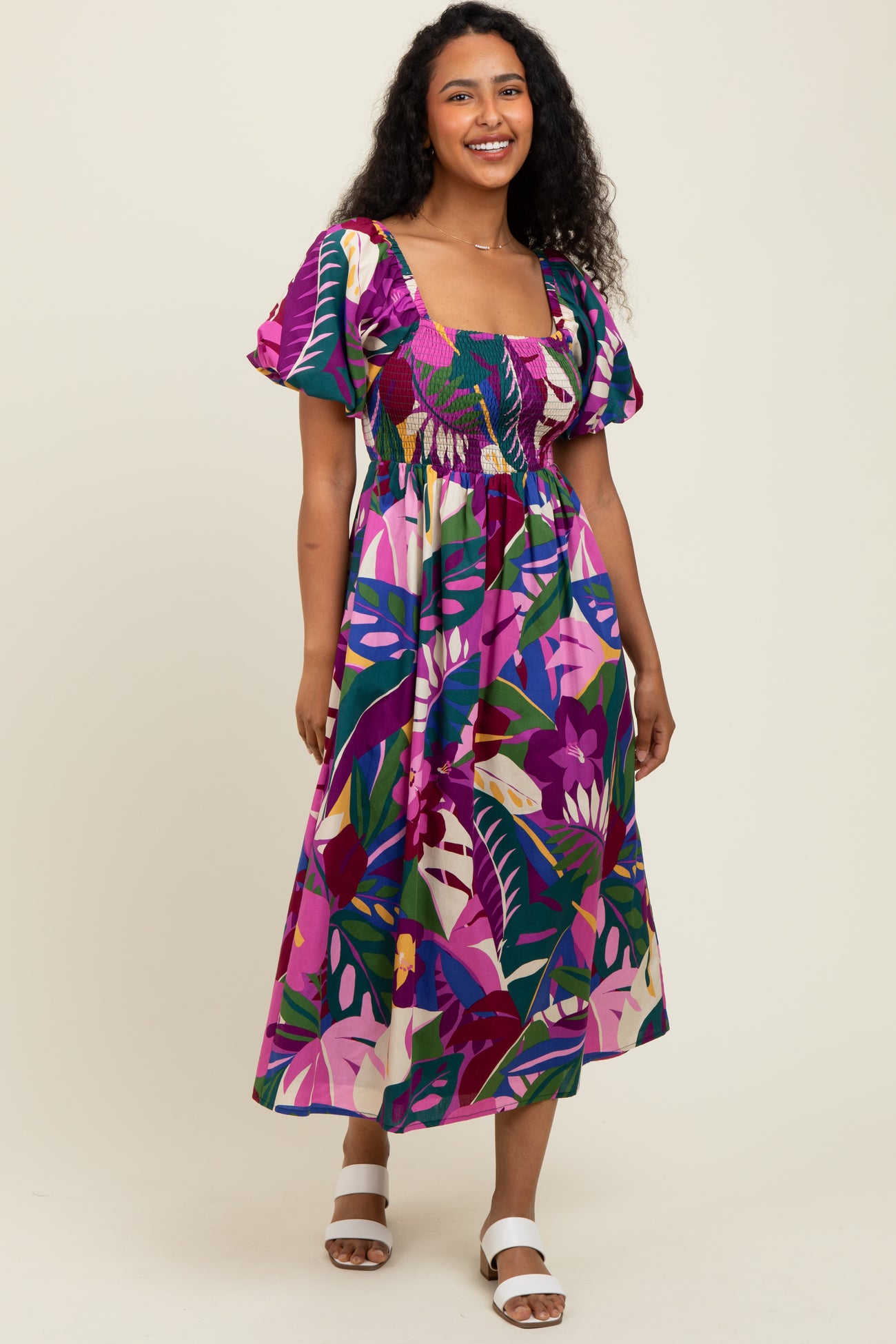 woman wearing a colorful floral print maxi dress with short puff sleeves and a smocked bodice