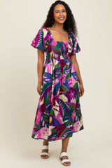 woman wearing a colorful floral print maxi dress with short puff sleeves and a smocked bodice