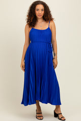 woman wearing a royal blue sleeveless maternity maxi dress with pleated details and a tie waist