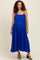 woman wearing a royal blue sleeveless maternity maxi dress with pleated details and a tie waist