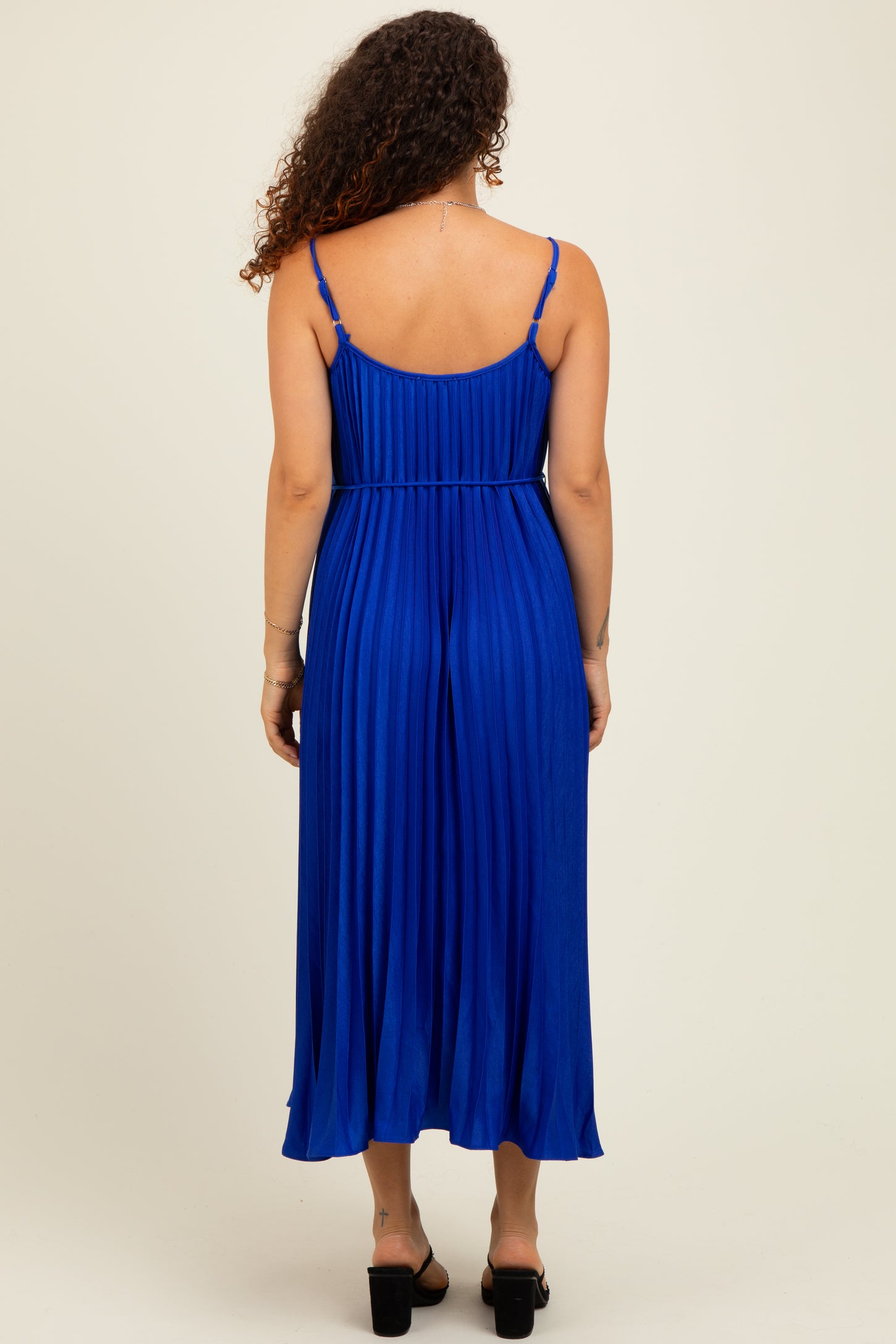 woman wearing a blue pleated maternity maxi dress, showing the back and a relaxed fit