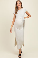 woman wearing a light grey maternity maxi dress with a side knot and side slit, showcasing her baby bump
