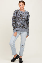 woman wearing a gray leopard print sweater and light blue distressed jeans, paired with black platform shoes