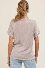 woman wearing a light brown striped maternity top, showing the back view with short sleeves and relaxed fit
