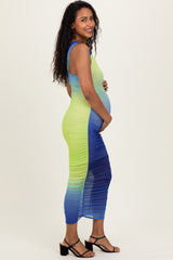woman wearing a gradient green to blue maternity dress, showcasing her baby bump, with a form-fitting style and side ruching