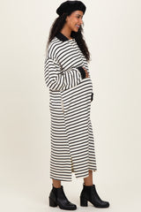 woman wearing a black and white striped maternity dress with a relaxed fit and side slits, showing her baby bump