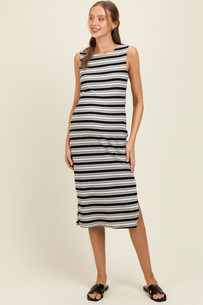 woman wearing a striped black and white sleeveless maternity dress with a side slit and a visible baby bump