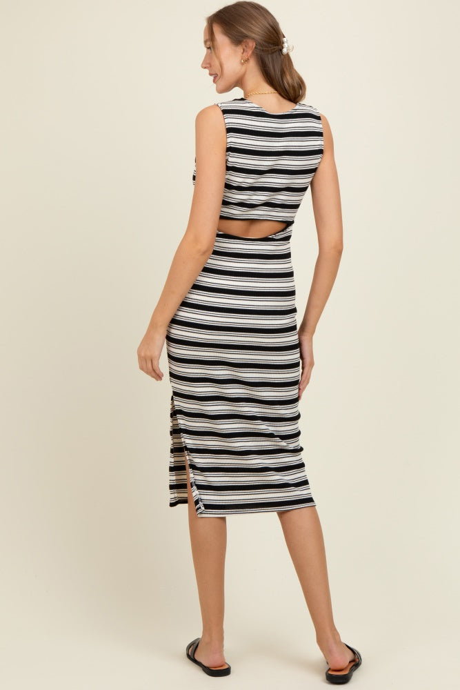 woman wearing a black and white striped maternity dress with a cutout back and side slit, showcasing her baby bump