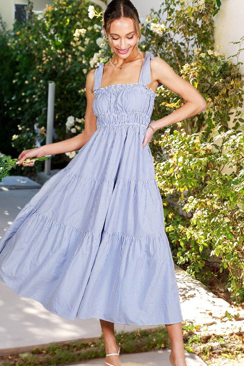 woman wearing a blue and white striped tiered maxi dress with smocked bodice and adjustable straps