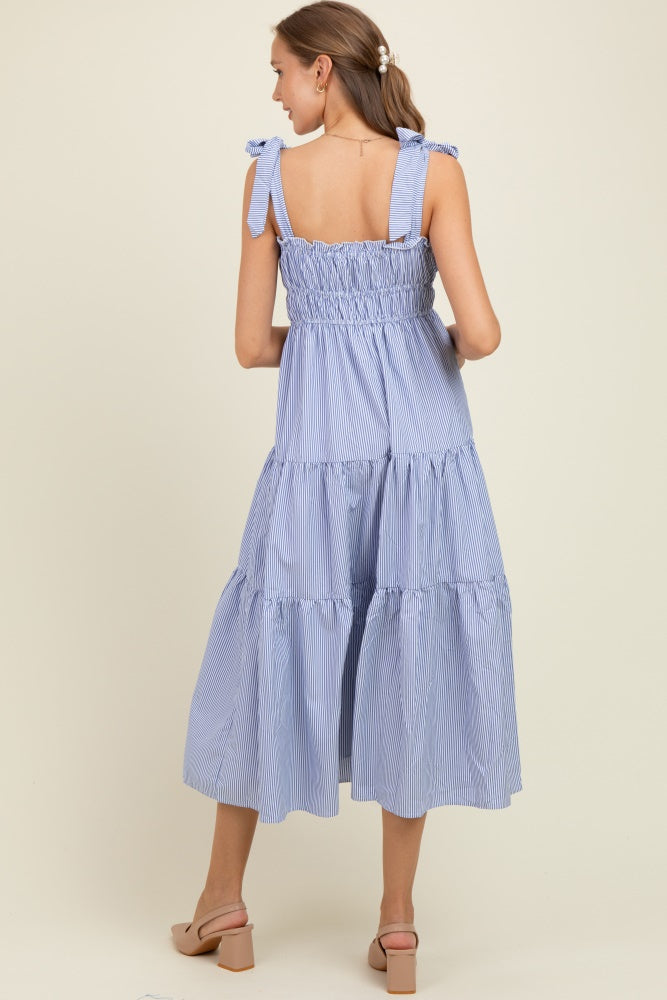 woman wearing a light blue striped maternity tiered maxi dress with ruffled straps and smocked bodice