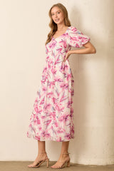 woman wearing a floral pink midi dress with puff sleeves and a fitted bodice