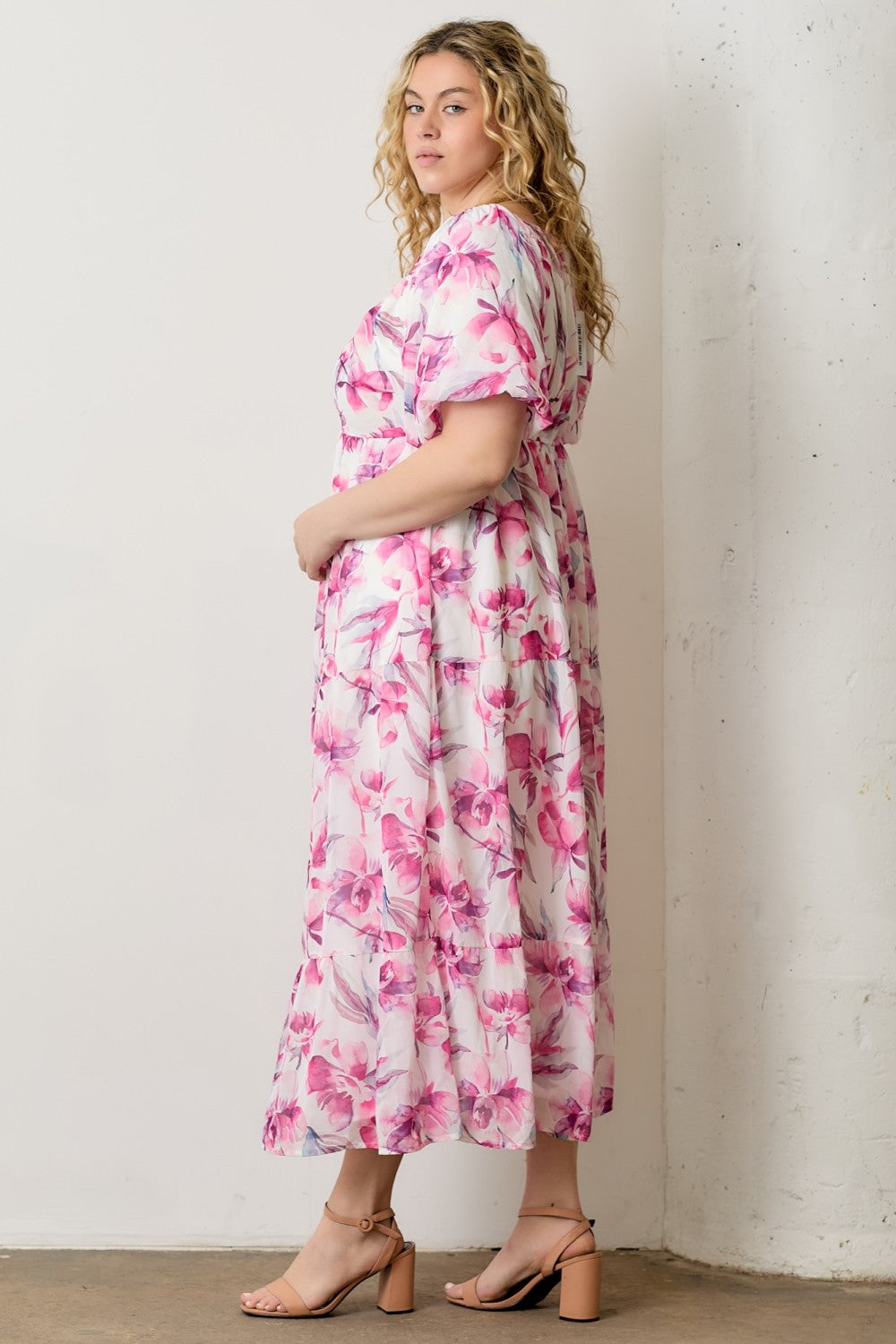 woman wearing a pink floral plus size maxi dress with short sleeves and a relaxed fit