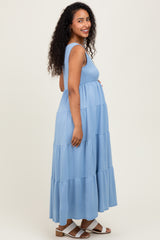 woman wearing a light blue tiered maxi maternity dress with a visible baby bump