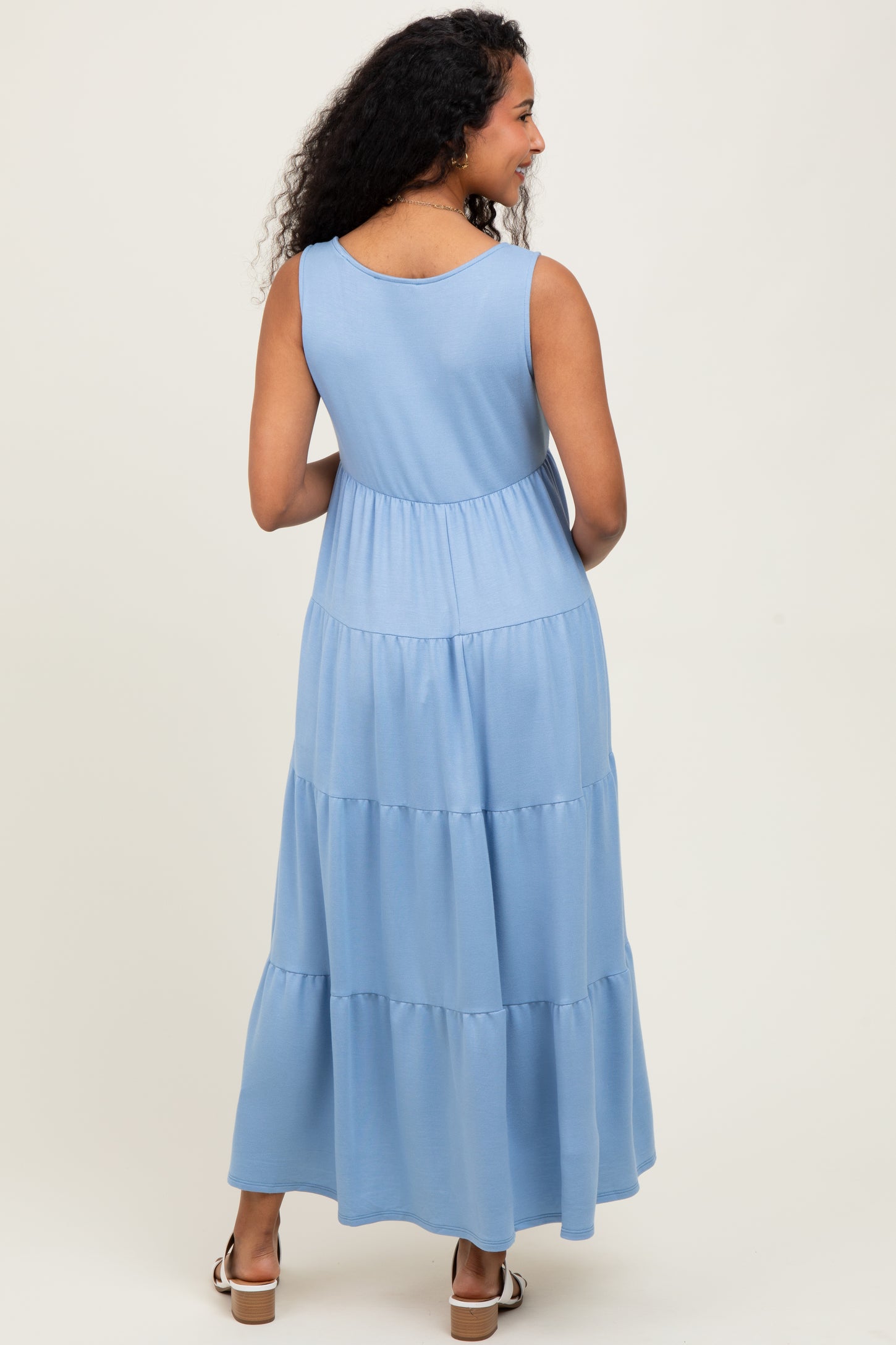 woman wearing a light blue maternity maxi dress with a tiered design, showing a relaxed fit and no visible baby bump
