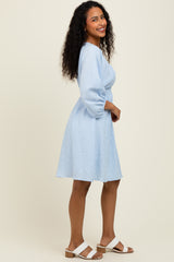 woman wearing a blue and white striped short sleeve dress with a fitted waist and a flared skirt, styled with flat sandals