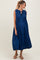 woman wearing a navy blue sleeveless maternity dress with pleats and a tie detail, showing her baby bump