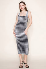 woman wearing a black and white checked midi dress with a square neckline and fitted silhouette