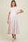 woman wearing a light pink maternity dress with short puff sleeves and a tiered skirt, showing a baby bump