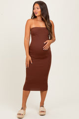woman wearing a brown strapless midi maternity dress and showing off her baby bump